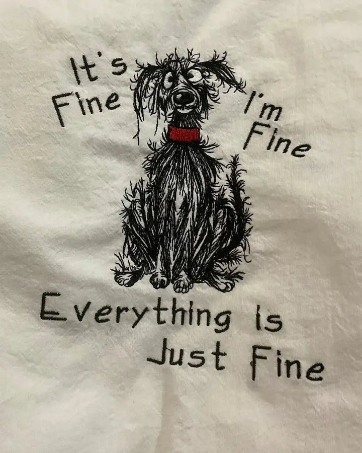 Embroidered kitchen towel with scruffy dog illustration and humorous saying, "It's fine, I'm fine, everything is just fine."