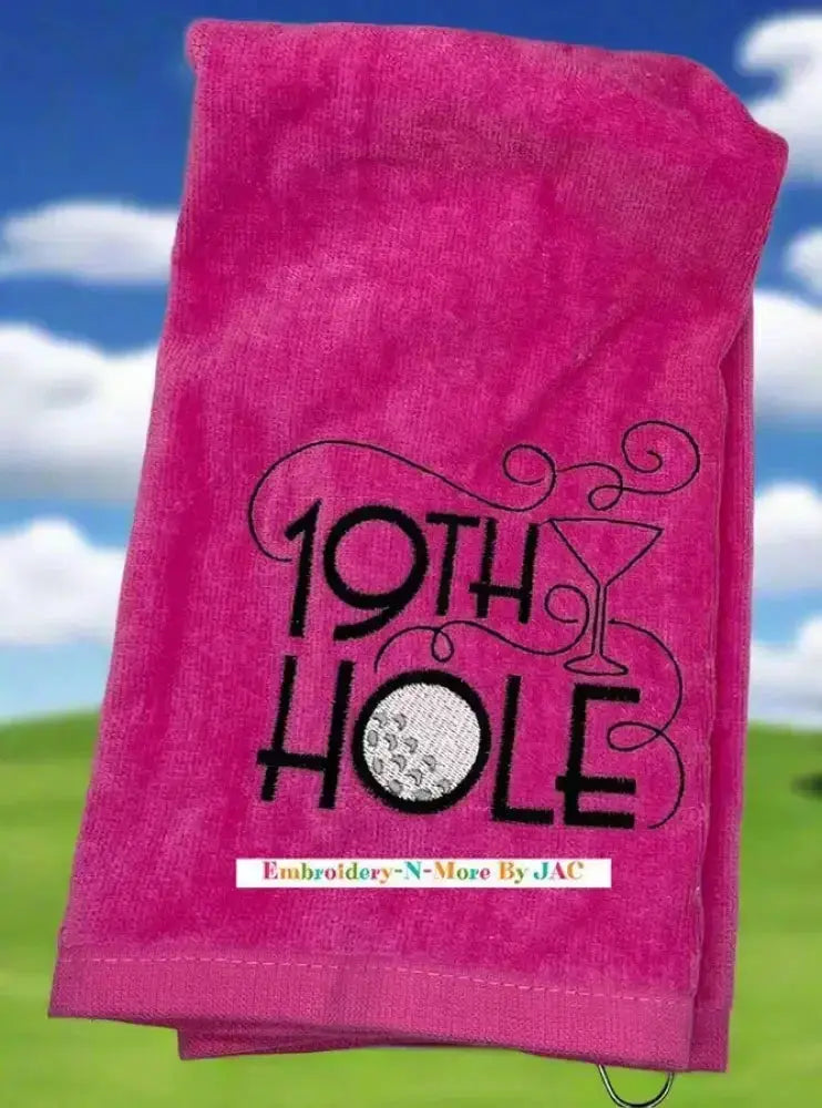Pink tri-fold golf towel with embroidered 19th Hole design, golf ball, and martini glass.