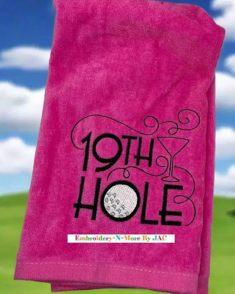 Pink tri-fold golf towel with embroidered 19th Hole design, golf ball, and martini glass.