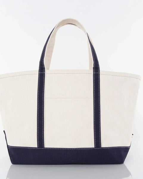 Large canvas tote bag with navy blue handles and bottom, plain front, white background
