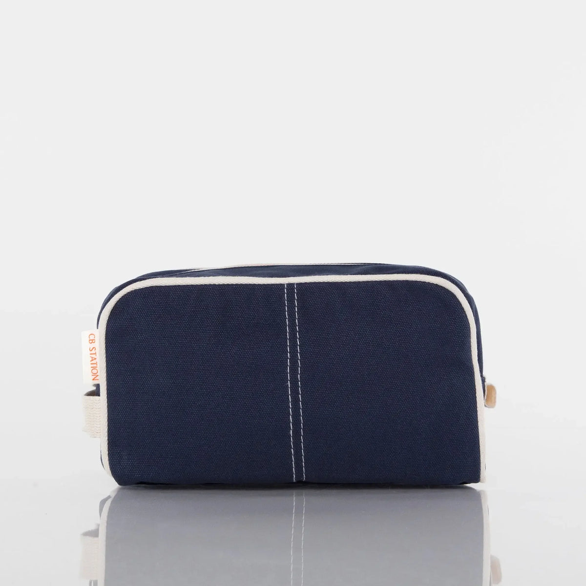 Navy blue canvas toiletry bag with white trim, front view, on white background