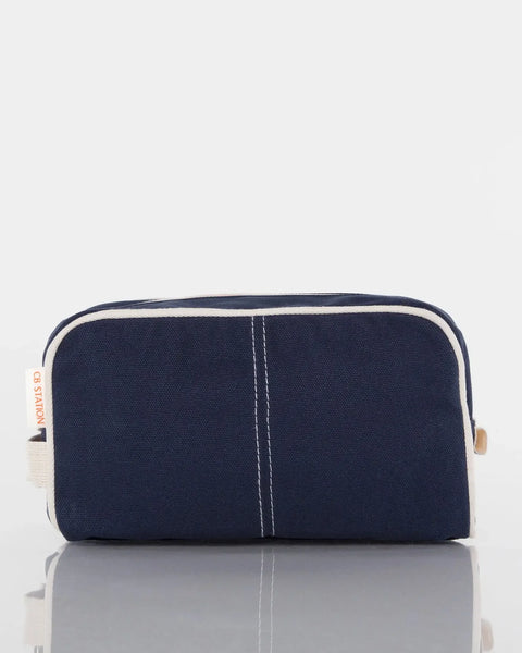 Navy blue canvas toiletry bag with white trim, front view, on white background