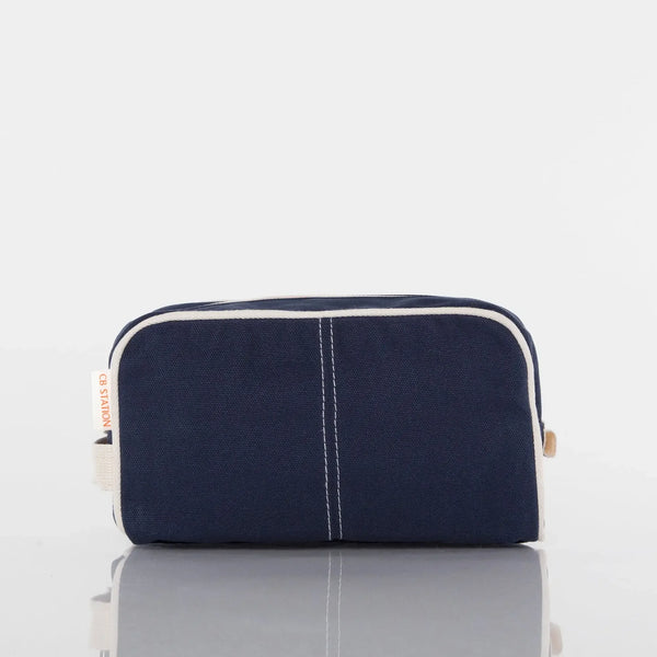 Navy blue canvas toiletry bag with white trim, front view, on white background