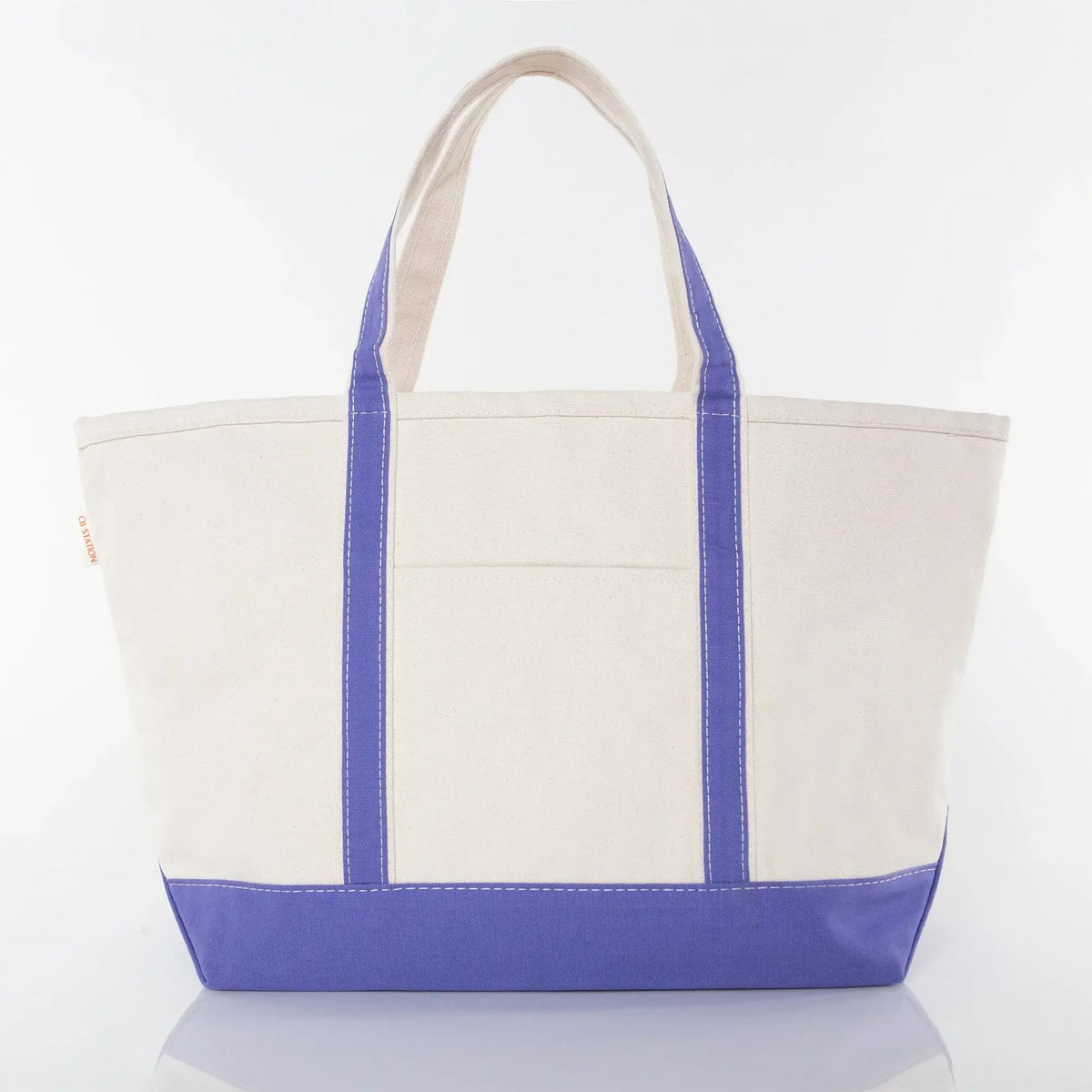 Large canvas tote bag with purple base, purple handles, and front pocket on white background