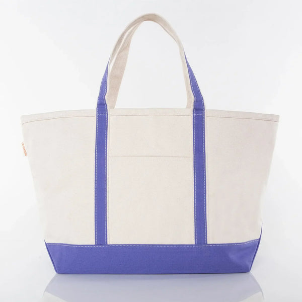 Large canvas tote bag with purple base, purple handles, and front pocket on white background