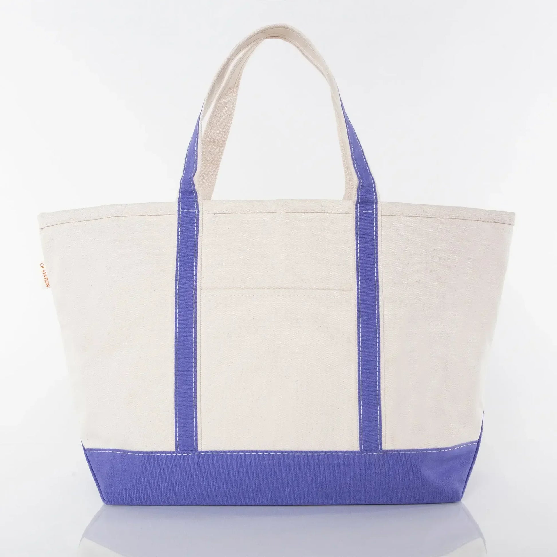 Large canvas tote bag with purple base, purple handles, and front pocket on white background