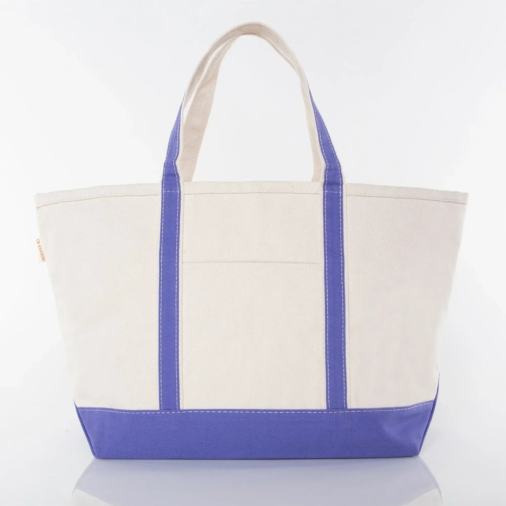 Large canvas tote bag with purple base, purple handles, and front pocket on white background