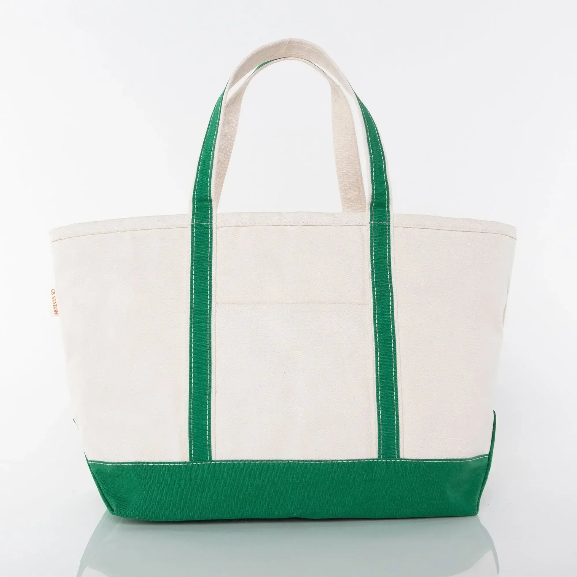 Canvas tote bag with green handles and bottom, large utility pocket, white background.