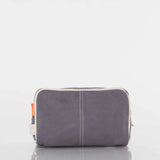 Gray canvas toiletry bag with white trim and orange side tag on white background