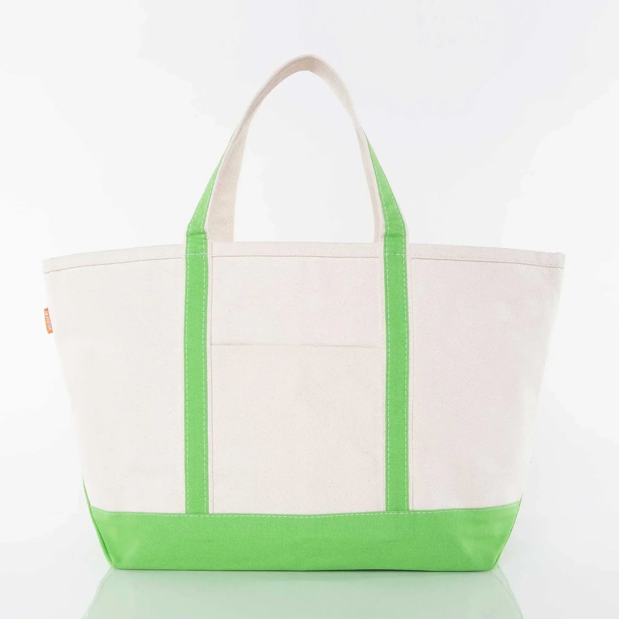 Canvas tote bag with green handles and base, front pocket, on white background