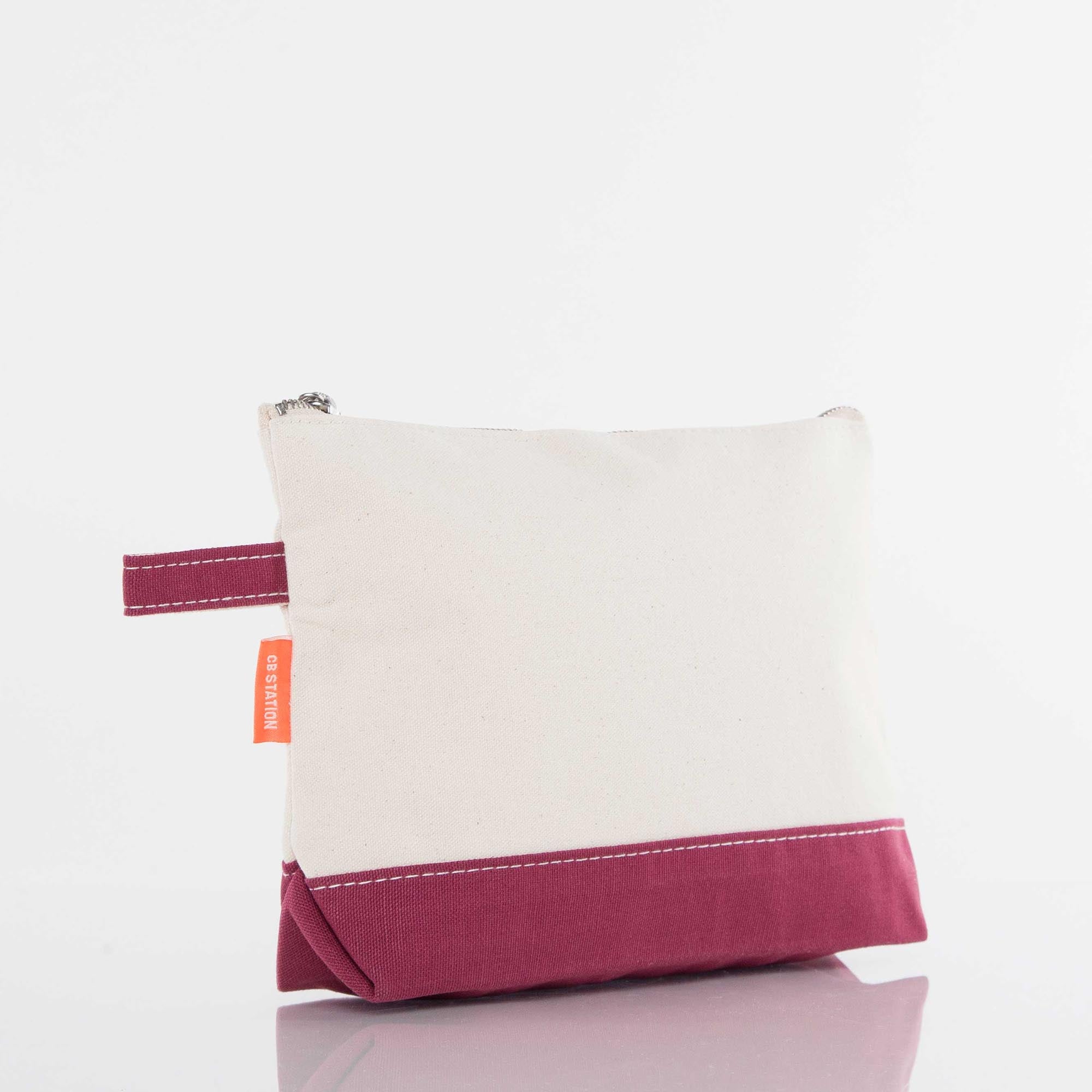 Two-tone canvas zipper pouch with maroon base and side handle on white background