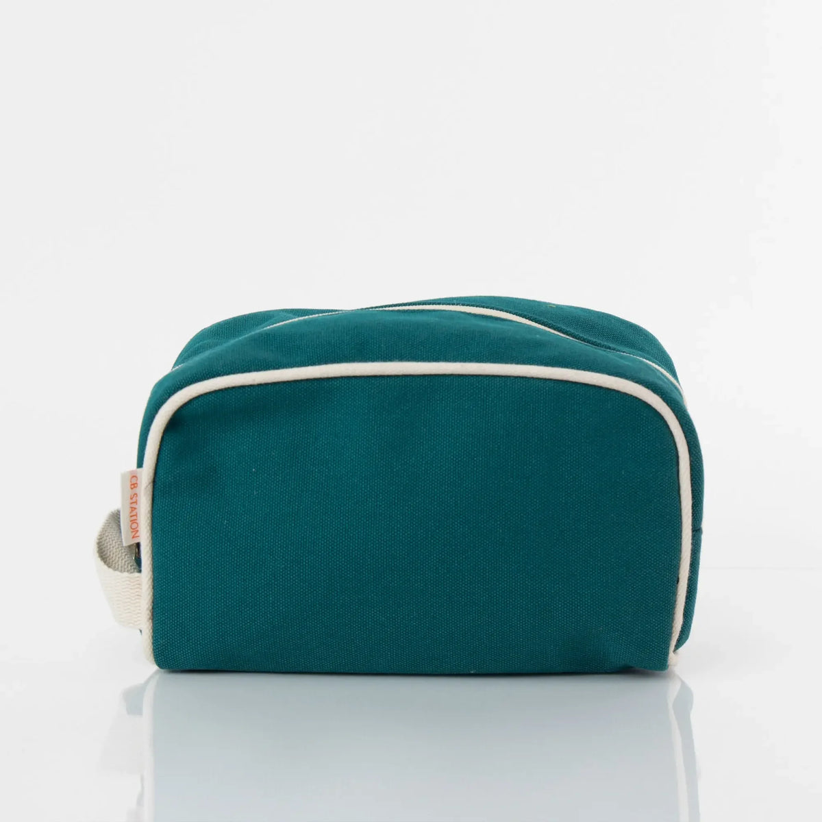 Teal canvas toiletry bag with cream trim and zipper, minimalist travel accessory.