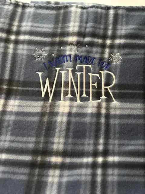 Plaid fleece blanket with embroidered I wasn't made for winter and snowflake design