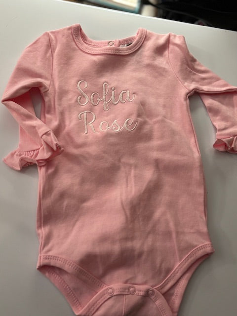 Personalized pink embroidered baby bodysuit with ruffled sleeves and 'Sofia Rose' text