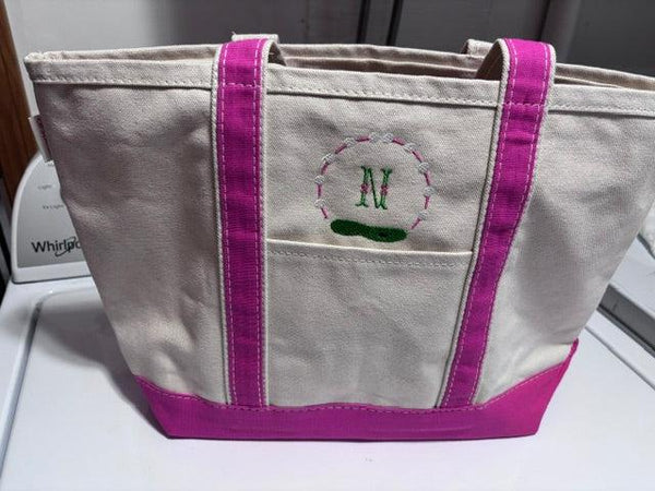 Personalized canvas tote bag with pink trim and embroidered initial N on front pocket