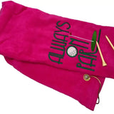 Pink embroidered tri-fold golf towel with Always On Par text, two wooden tees, metal grommet