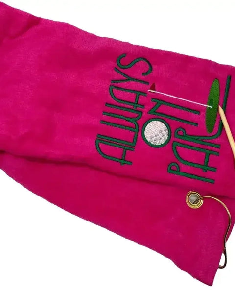 Pink embroidered tri-fold golf towel with Always On Par text, two wooden tees, metal grommet