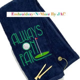 Navy tri-fold golf towel with 'Always On Par' embroidery, golf tees, and clip attachment.