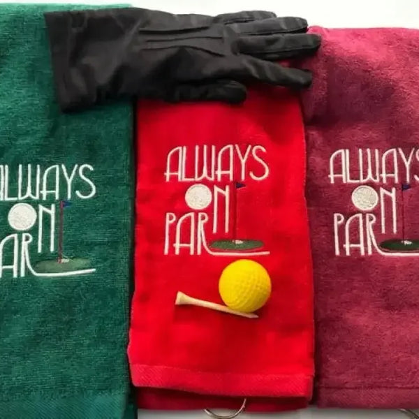 Tri-fold golf towels with 'Always On Par' embroidery, glove, yellow golf ball and tee