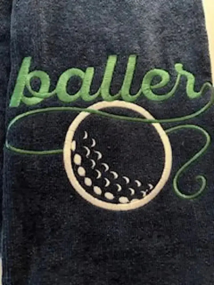 Embroidered golf towel with green baller text and white golf ball design