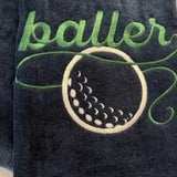 Navy blue golf towel with green baller text and embroidered golf ball design