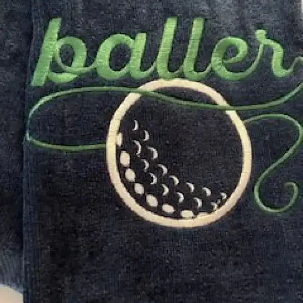 Navy blue golf towel with green baller text and embroidered golf ball design
