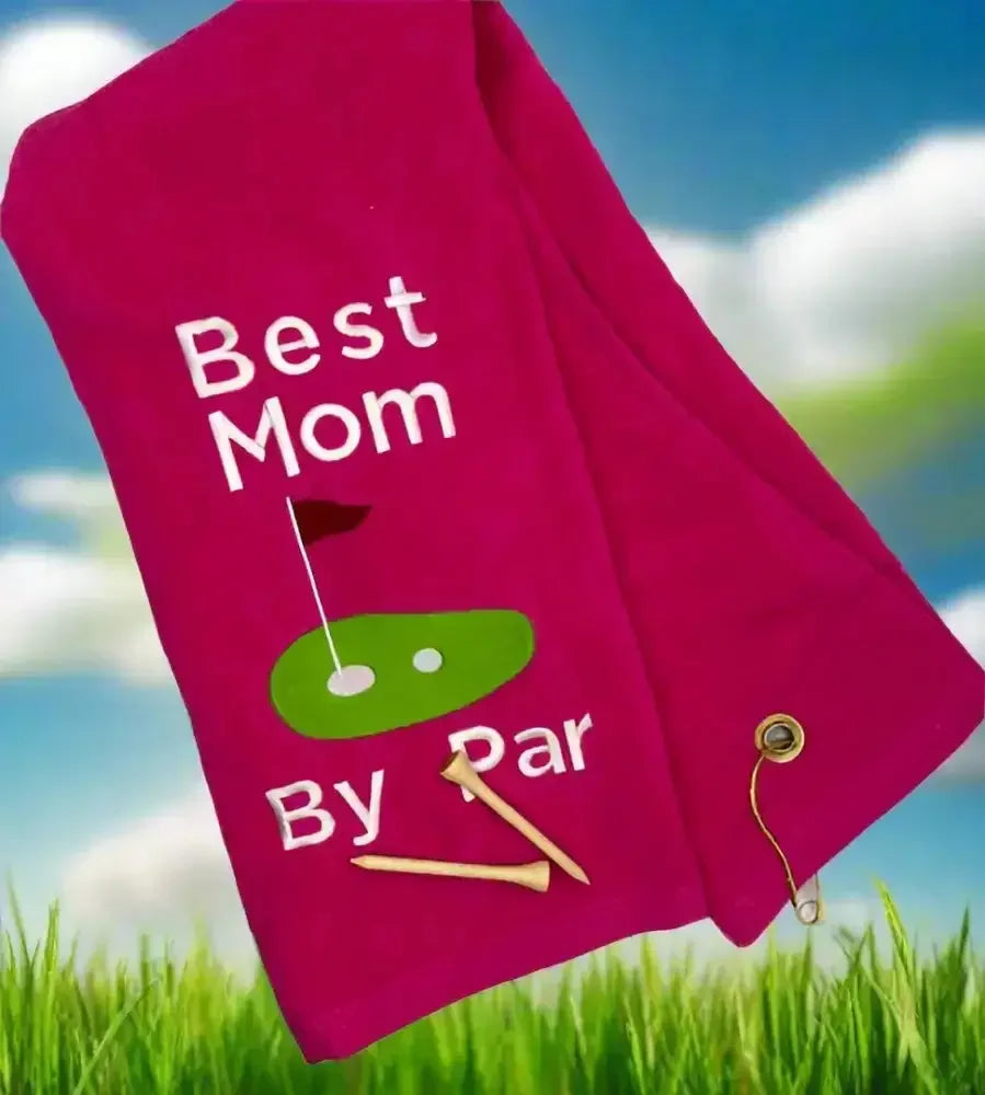 Pink embroidered golf towel with 'Best Mom by Par' text, golf green graphic, and two tees