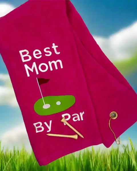 Pink embroidered golf towel with 'Best Mom by Par' text, golf green graphic, and two tees