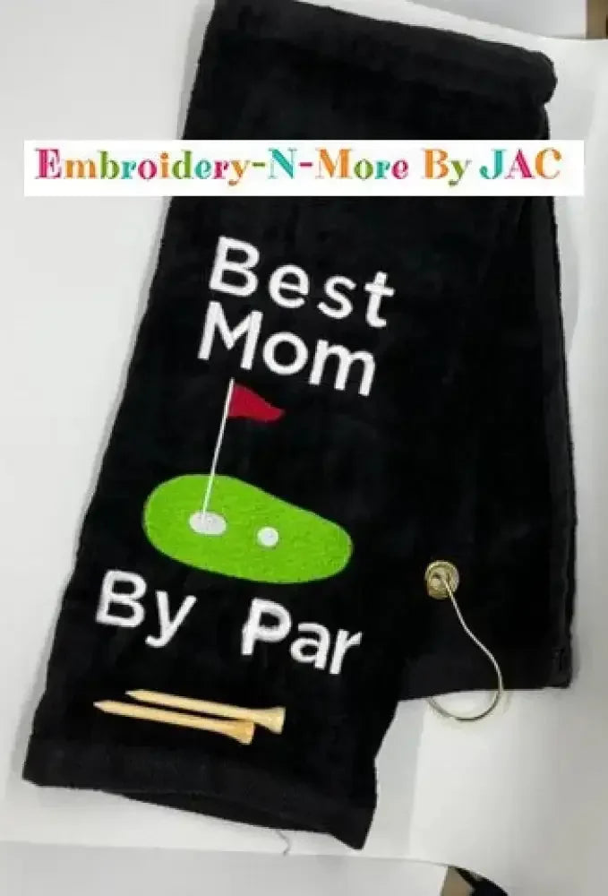 Black tri-fold golf towel with Best Mom By Par embroidery, golf tee, and hook clip
