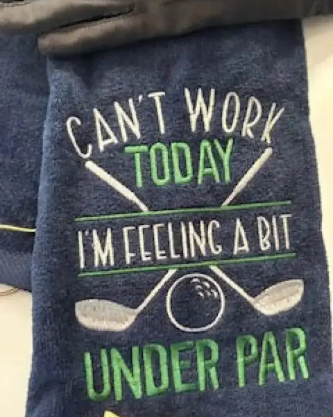 Embroidered navy golf towel with crossed clubs, golf ball, and humorous text design