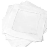 Set of plain white fabric cocktail napkins with hemstitch border, stacked.
