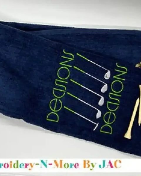 Navy tri-fold golf towel with embroidered green 'Decisions' text, golf clubs, and tees