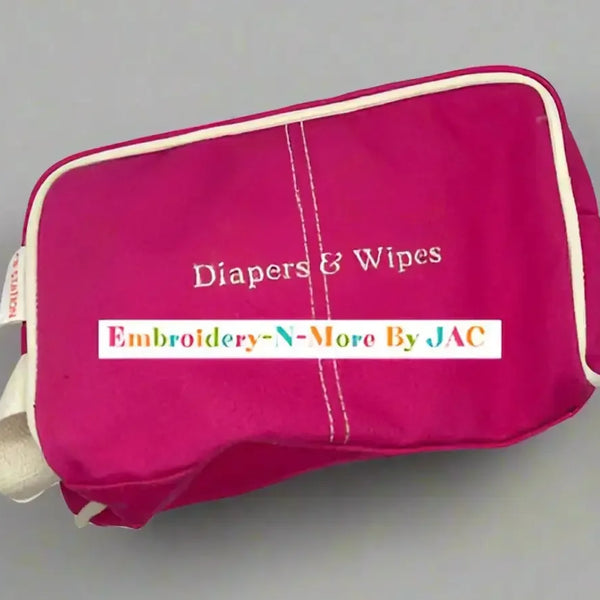 Pink diaper and wipes case bag with embroidered text, zip closure, and white trim.