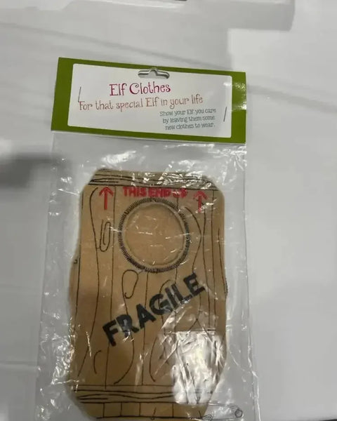 Elf costume with wood print and 'FRAGILE' text, packaged for holiday gifting.