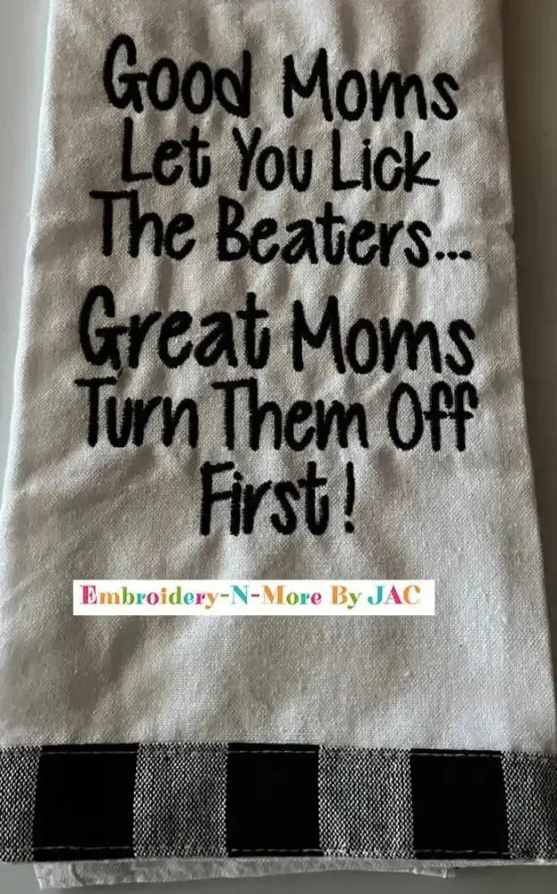 White flour sack kitchen towel with humorous embroidered text and black plaid border.