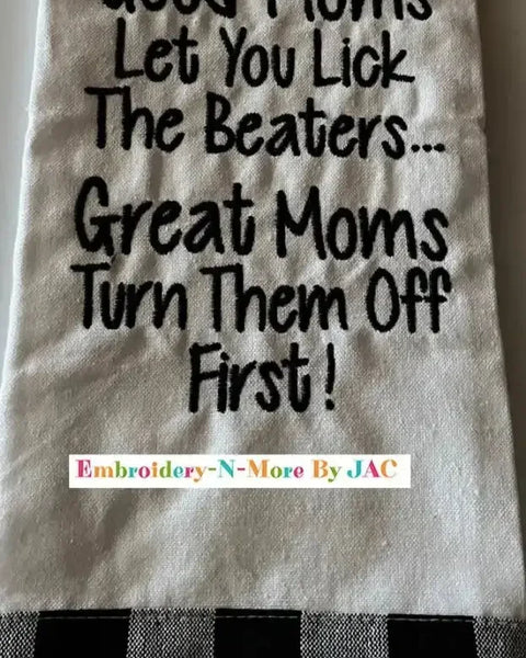 White flour sack kitchen towel with humorous embroidered text and black plaid border.