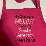 Hot pink apron with humorous white and black embroidered cooking quote on the front