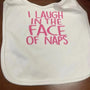 White baby bib with pink embroidered text saying 'I laugh in the face of naps'