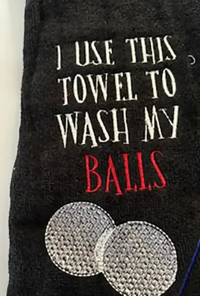 Black embroidered golf towel with text and two white golf balls design