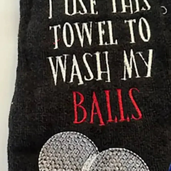 Black embroidered golf towel with text and two white golf balls design