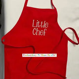Red child apron with 'Little Chef' embroidered in white, perfect for kids cooking or baking.