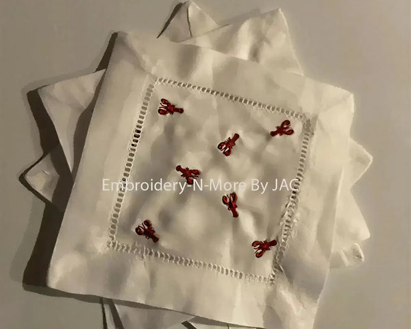 White cocktail napkin set with red lobster embroidery and hemstitch border