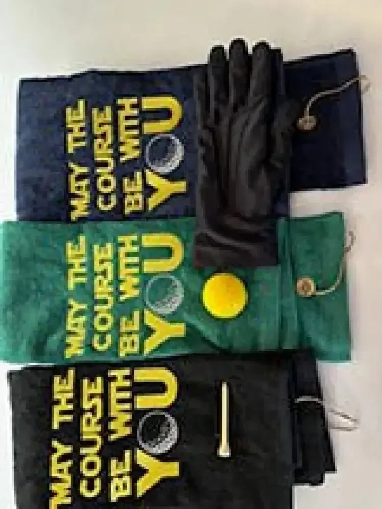 Embroidered golf towels with 'May the Course Be With You' text, golf glove, tees, and ball.
