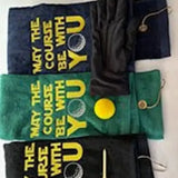 Embroidered golf towels with 'May the Course Be With You' text, golf glove, tees, and ball.