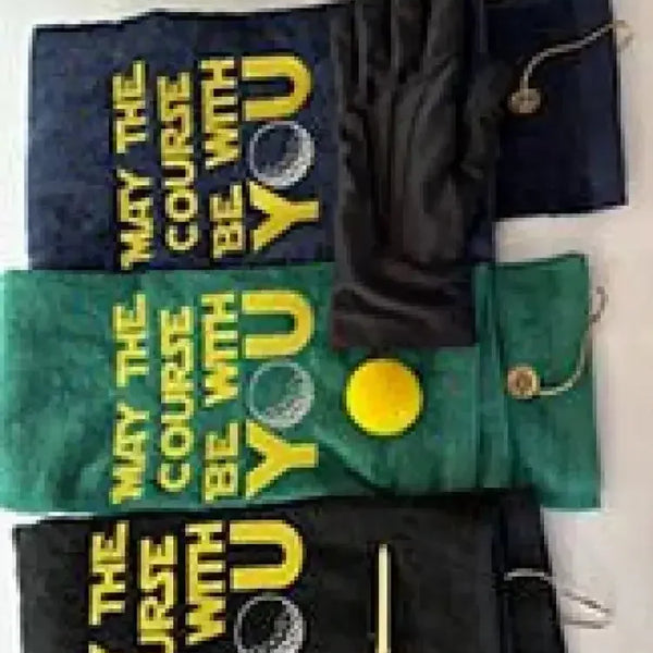 Embroidered golf towels with 'May the Course Be With You' text, golf glove, tees, and ball.