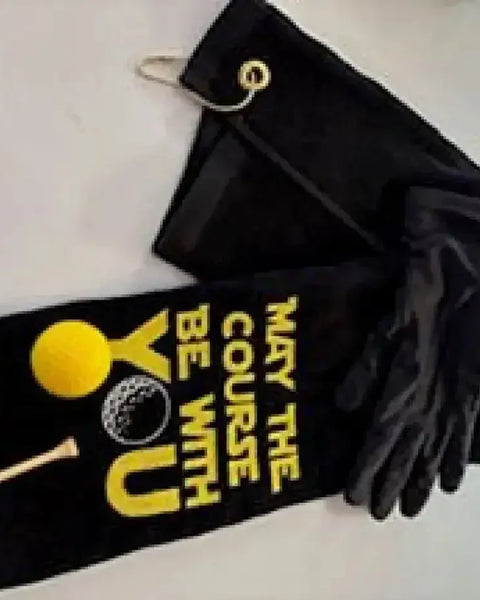 Black embroidered golf towel with yellow golf ball and tee, and 'May the Course Be With You' text