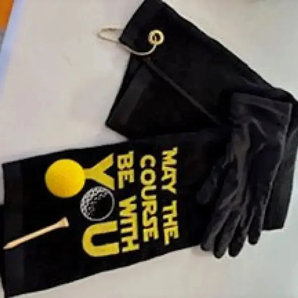 Black embroidered golf towel with yellow golf ball and tee, and 'May the Course Be With You' text