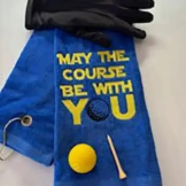 Blue embroidered golf towel with 'May the course be with you' text, golf glove, ball, and tee