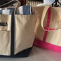 Personalized embroidered tote bags in beige with blue and pink accents, featuring names.