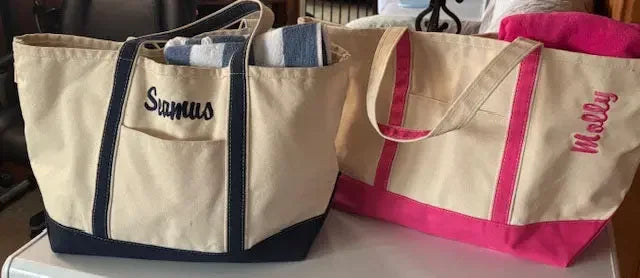 Personalized embroidered tote bags in beige with blue and pink accents, featuring names.